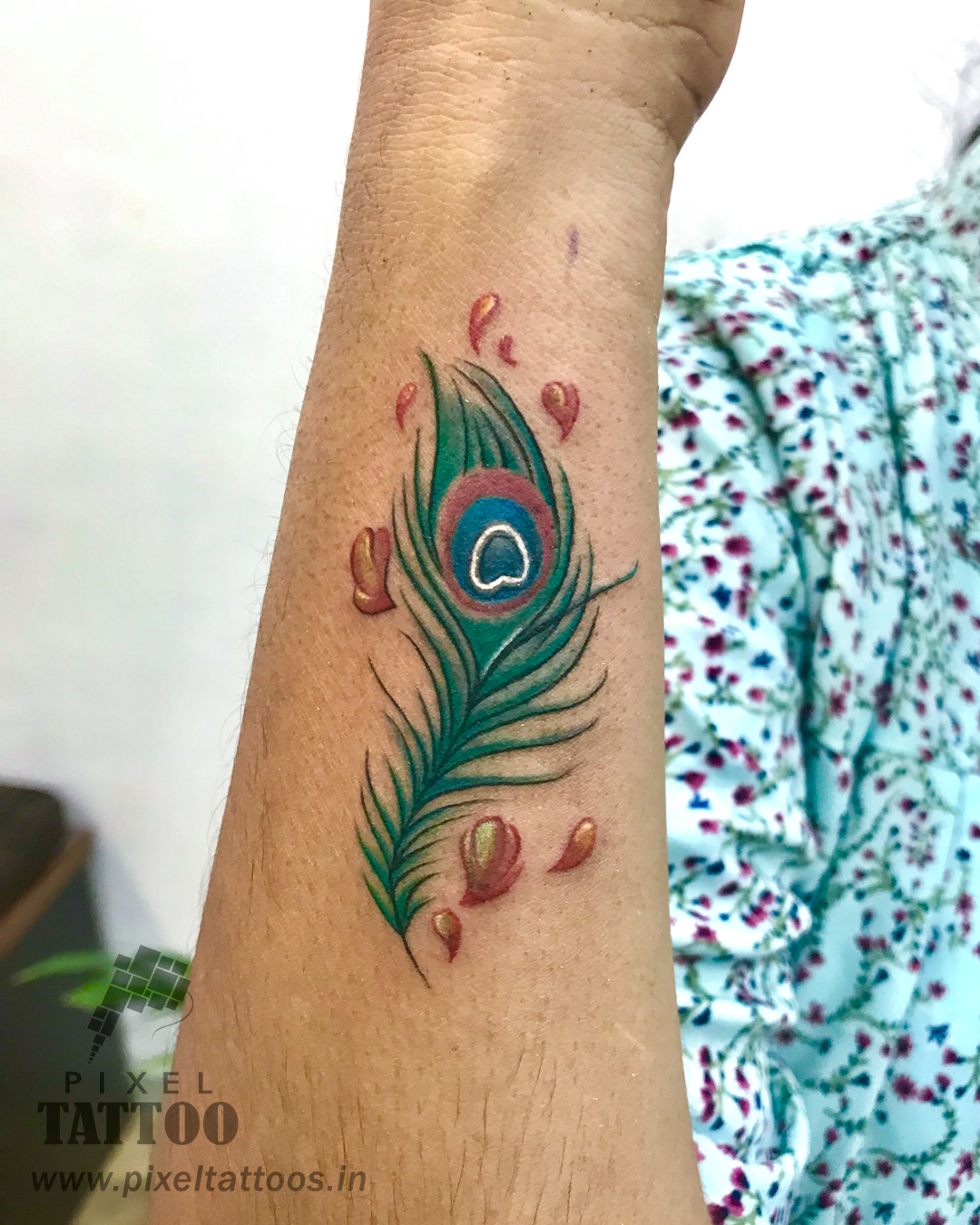 Peacock feather tattoo on wrist